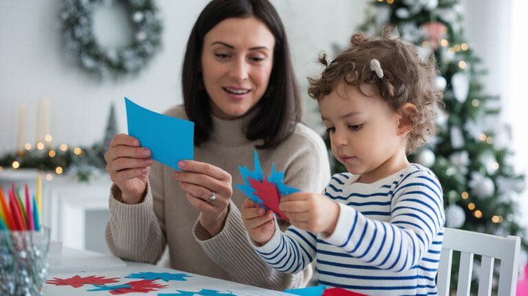 A photo of a mother and her child working together on a holiday craft project