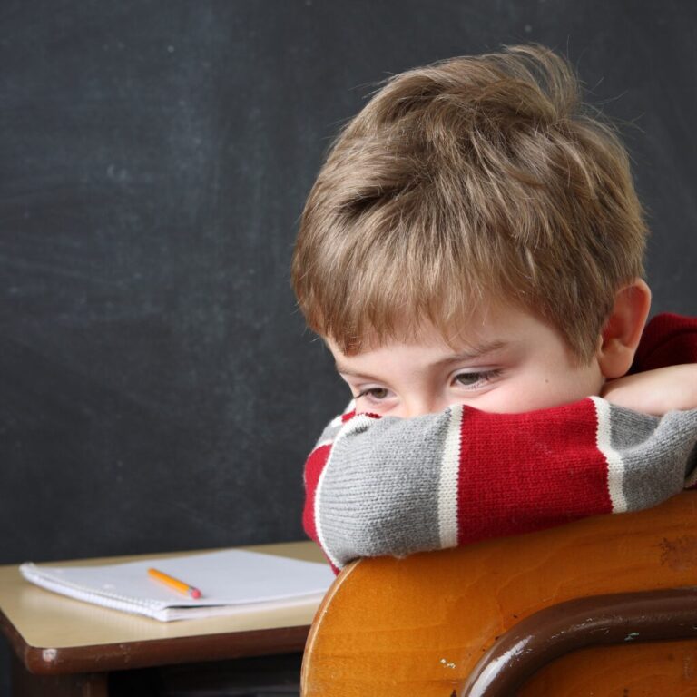 autistic child alone on a school chair feeling isolated due to selective mutism