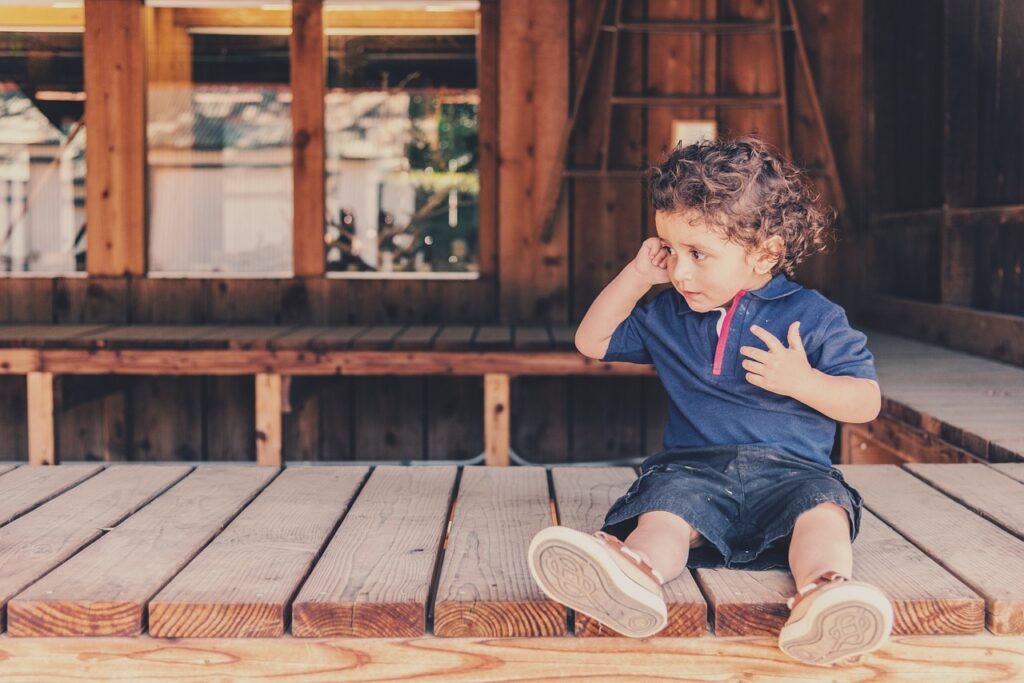 child sitting on the ground near the front door