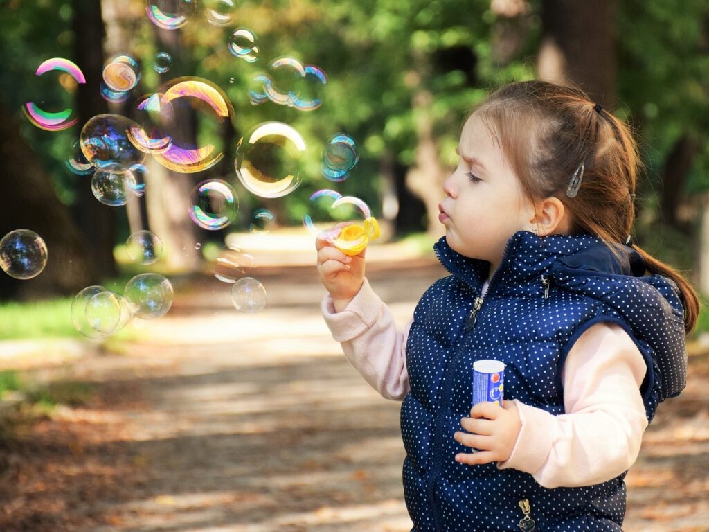 kid playing with soap bubbles