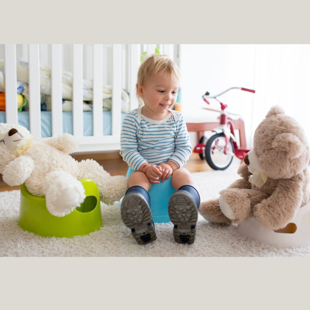 child sites on potty surronded by plush teddy bears sitting near him on potty chairs