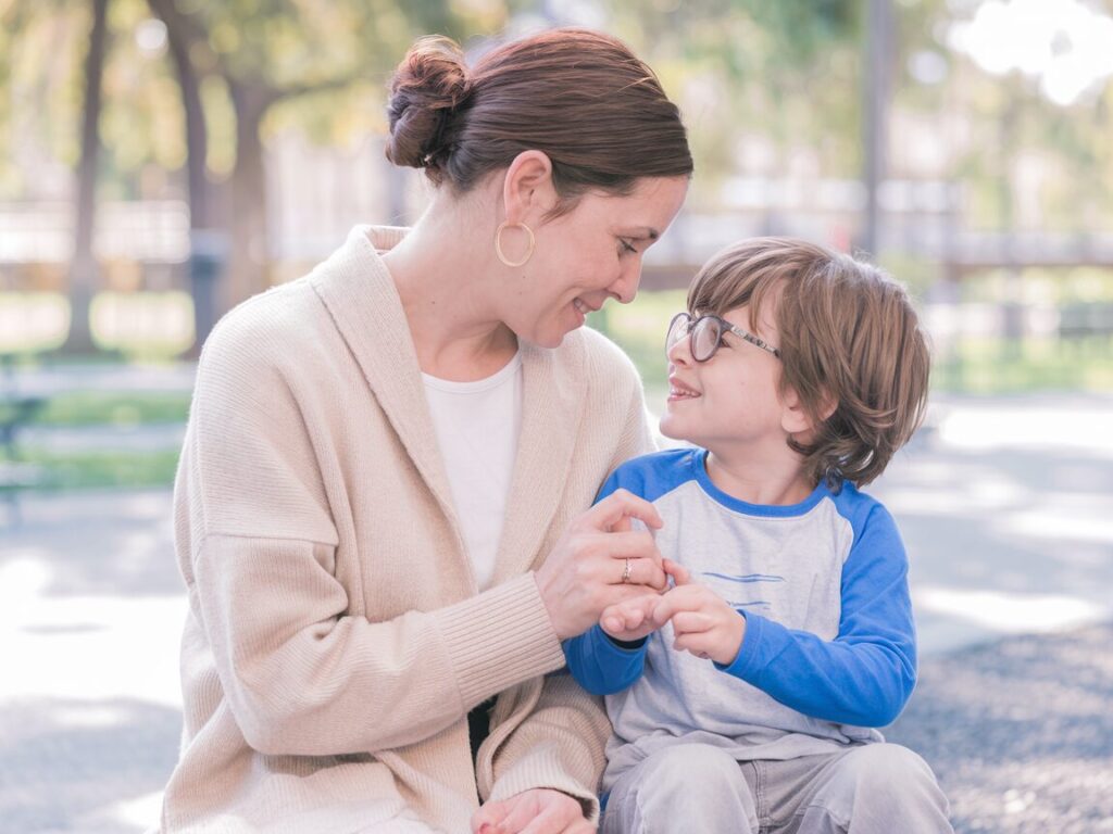 A soft, warm photo of a mother and child sitting together, sharing a moment of quiet connection.